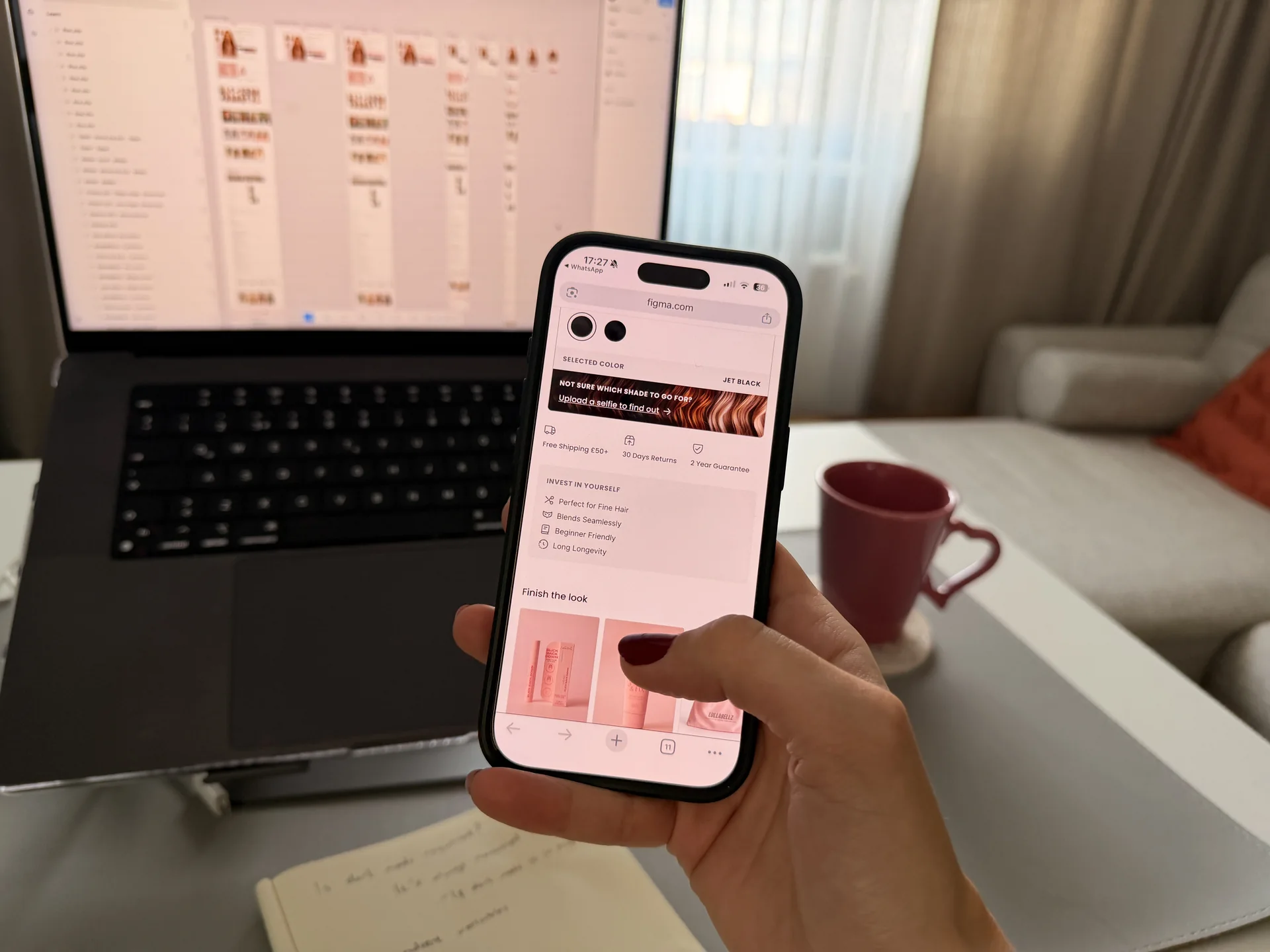 Person testing a mobile interface beside a laptop